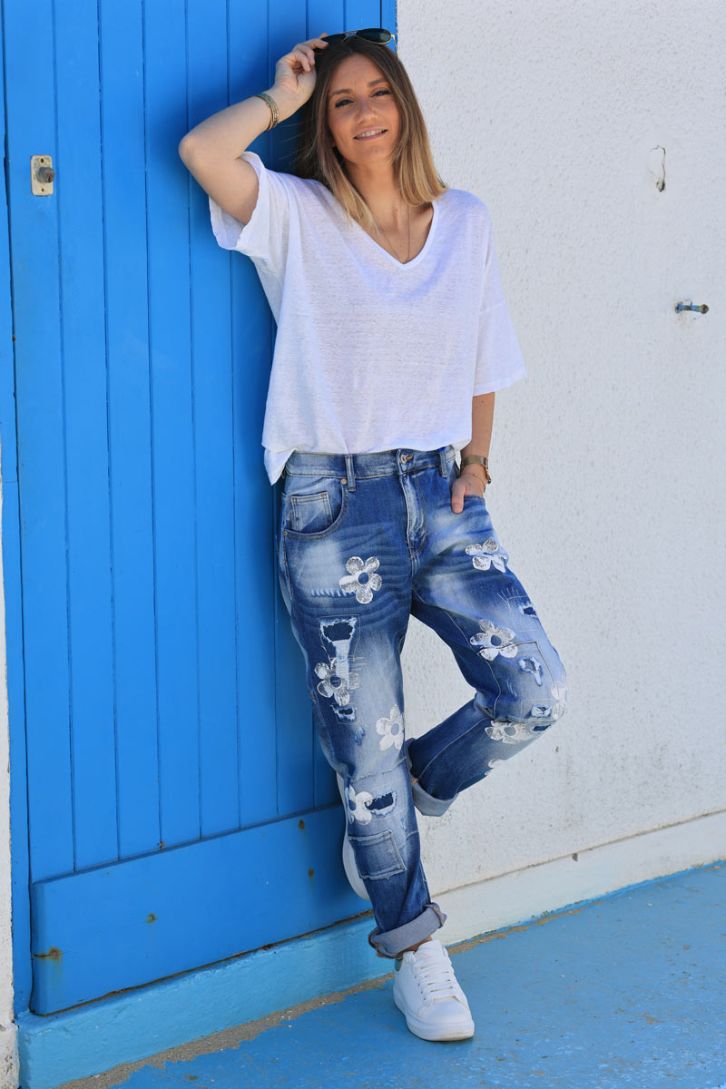 Mid-wash distressed jeans with white paint flower print