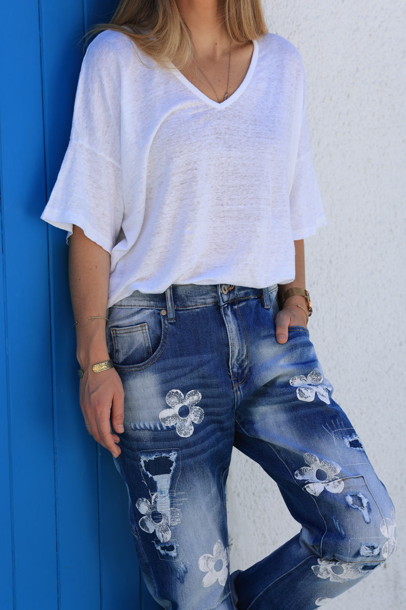 Mid-wash distressed jeans with white paint flower print