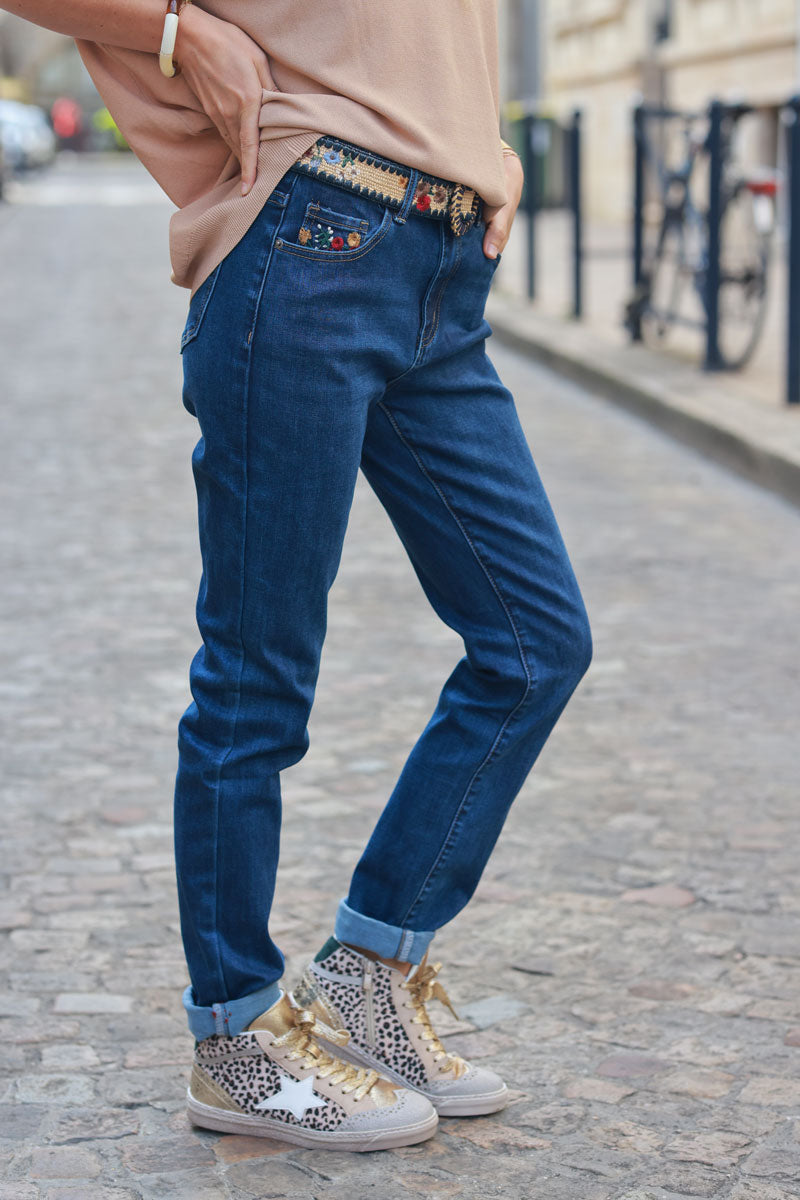 Jeans lavado medio con bordado de flores de colores, bolsillos y cinturón de rafia bordado