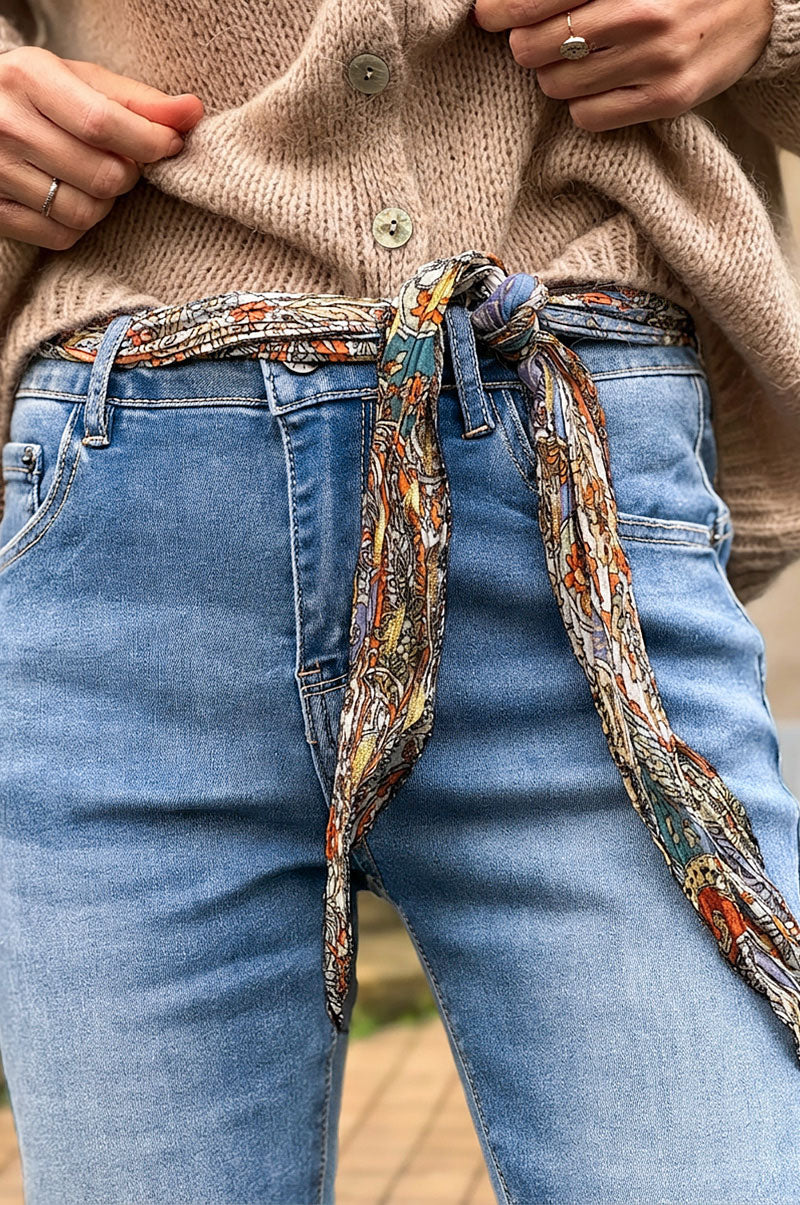 Vaqueros slim lavados con detalles estampados, puños y cinturón tipo pañuelo.