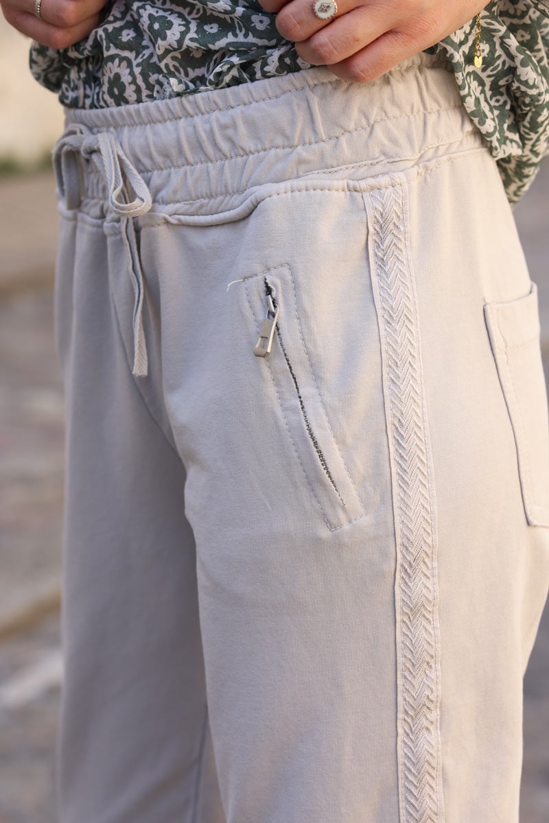 Jogging beige en coton ceinture elastique et poches zips lisere broderie chevrons H114 (1)