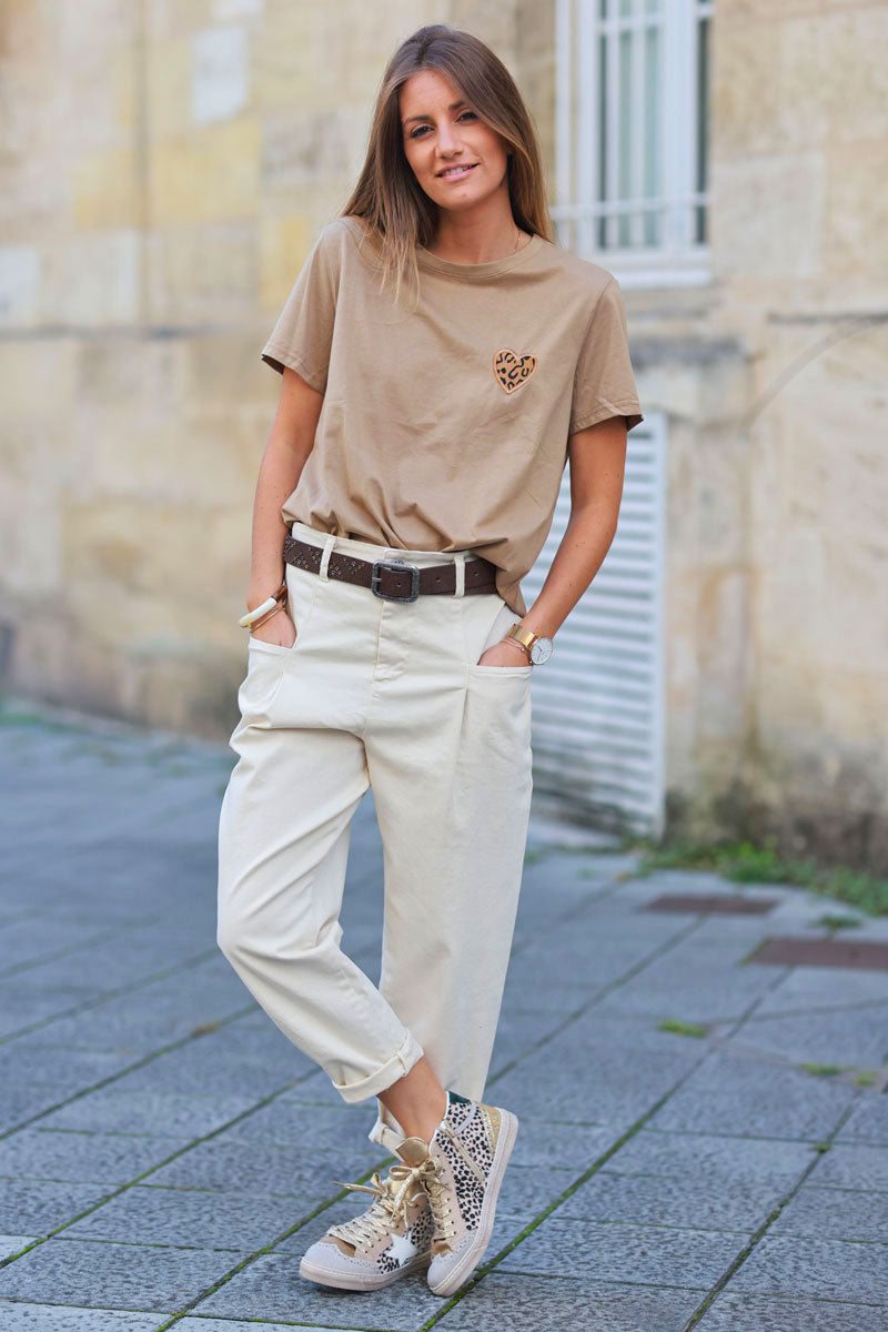 Pantalón beige corte zanahoria con pinzas, bolsillos y cinturón con tachuelas