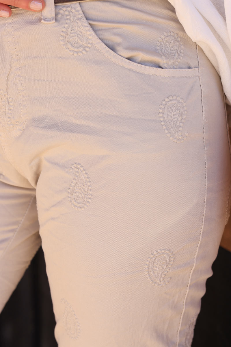 Beige slim fit pants with paisley embroidery and faux leather belt
