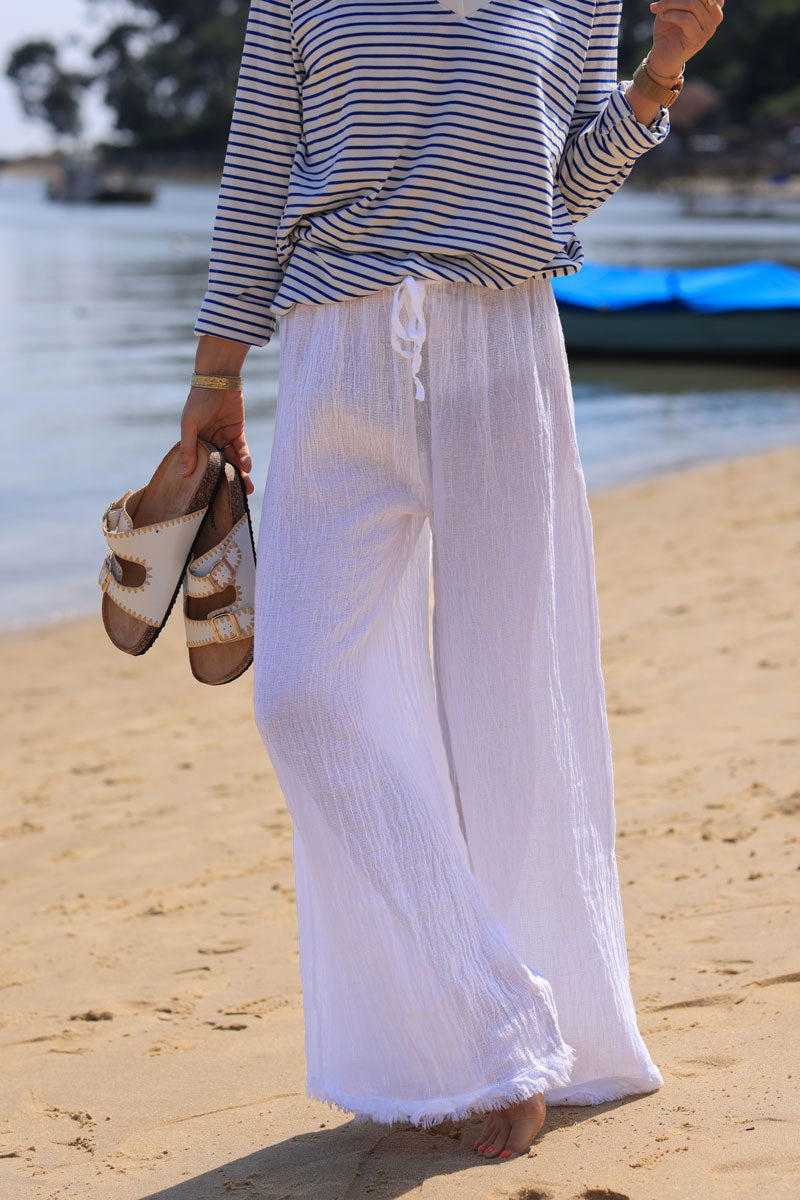 Wide leg white cotton and linen trousers with fringed hems