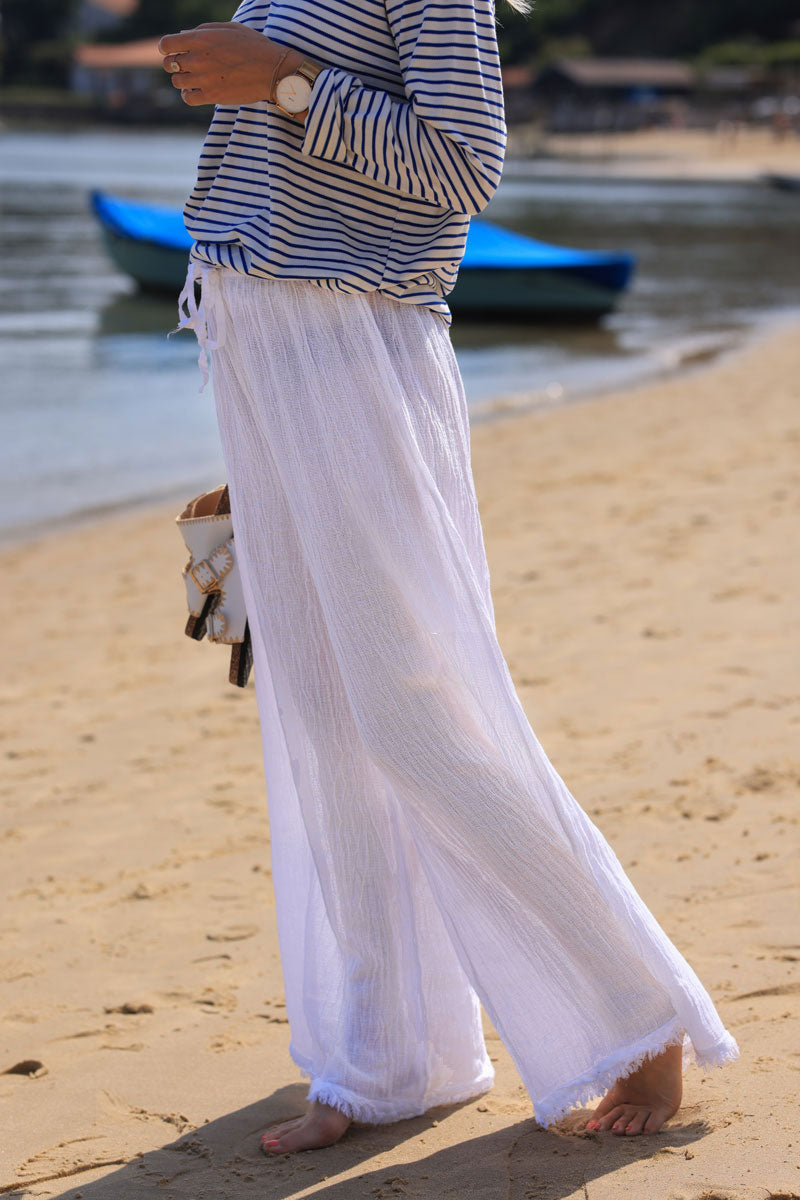 Wide leg white cotton and linen trousers with fringed hems