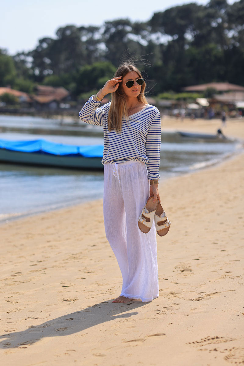 Wide leg white cotton and linen trousers with fringed hems