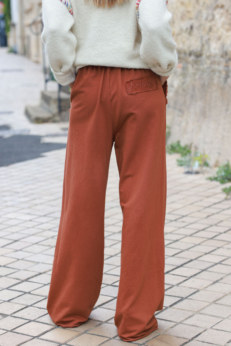 Pantalón jogging terracota de gran comodidad, cinturilla elástica, bolsillos con flecos