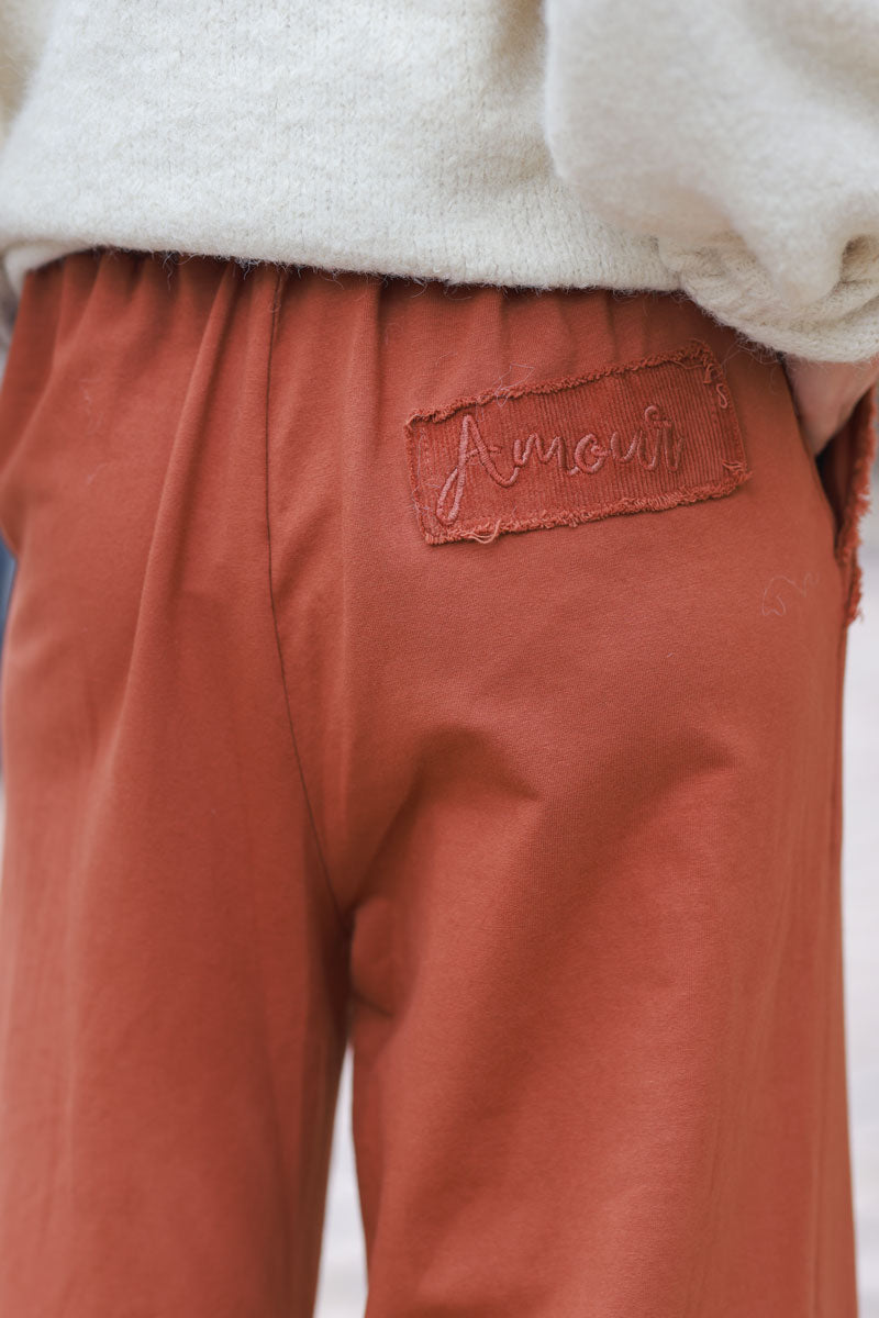 Pantalón jogging terracota de gran comodidad, cinturilla elástica, bolsillos con flecos