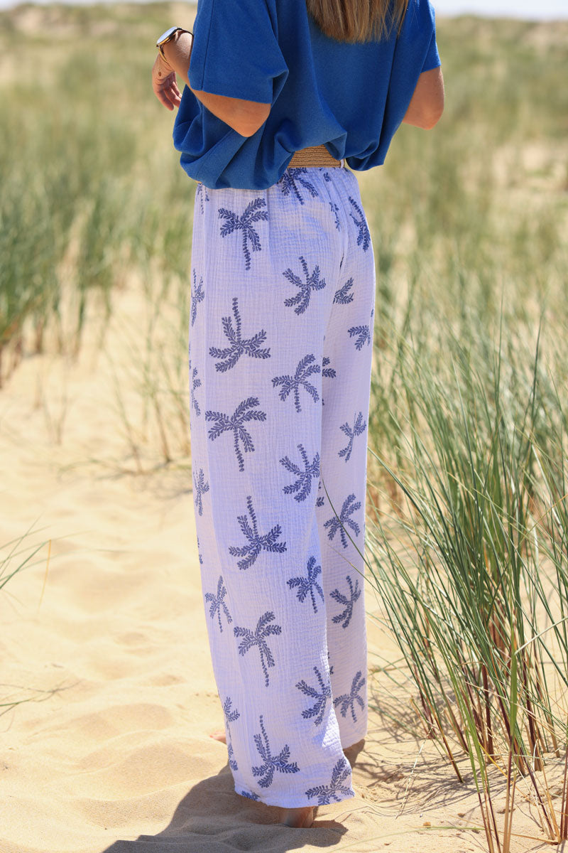 Pantalon en gaze de coton blanc imprimé palmiers bleu jean effet broderie avec ceinture raphia