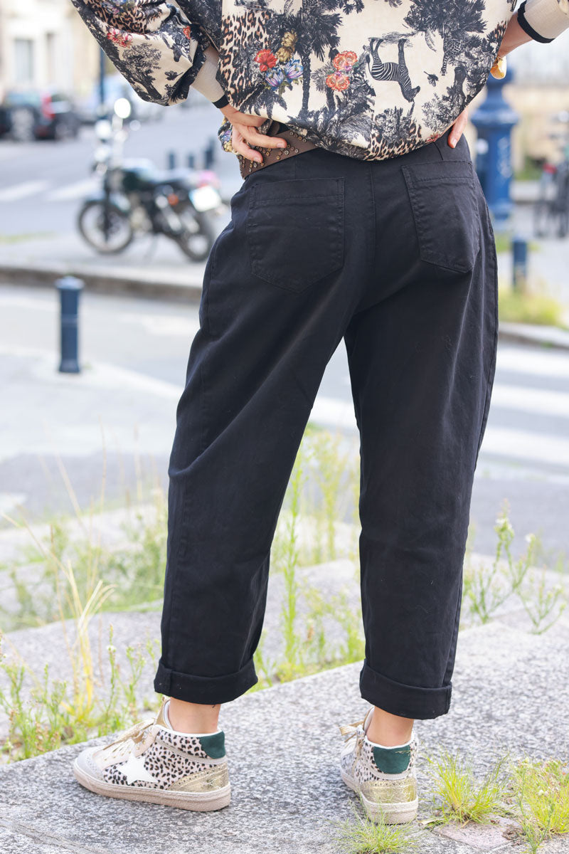 Pantalón negro de lona corte carrot plisado con bolsillos y cinturón con tachuelas