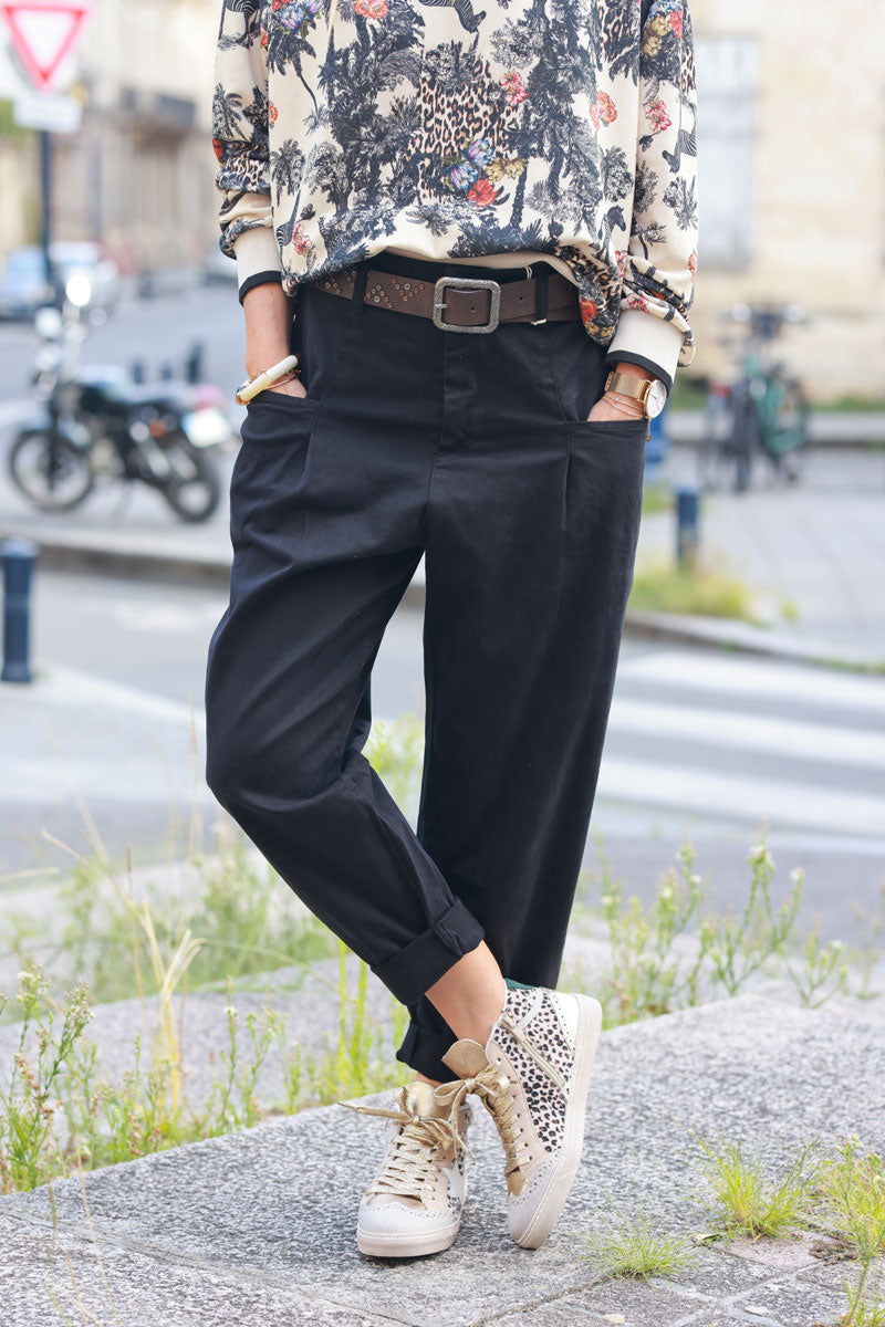 Pantalón negro de lona corte carrot plisado con bolsillos y cinturón con tachuelas