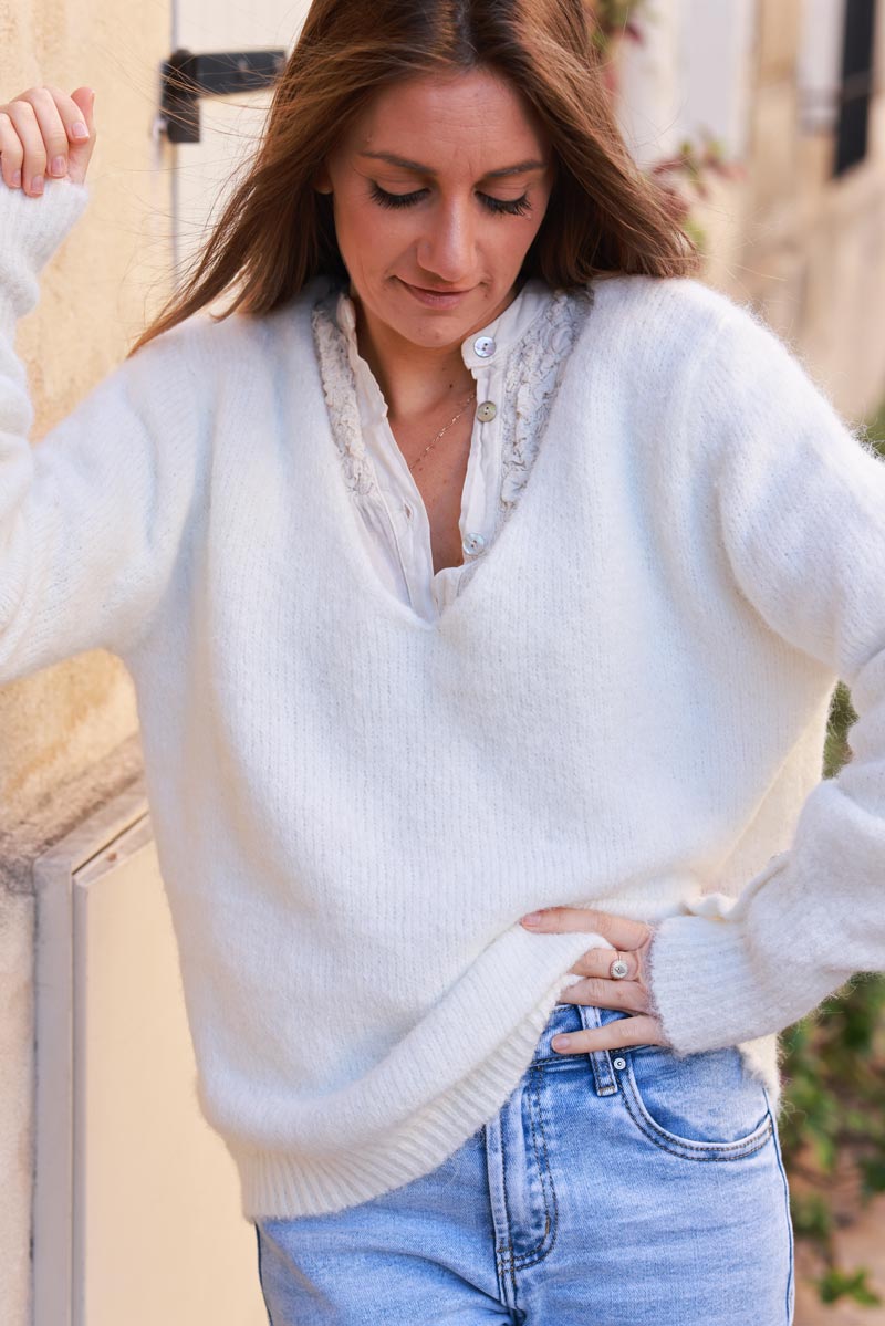 Suéter de punto suave y acogedor en color blanco roto con cuello en V, mangas fruncidas y botones de flores