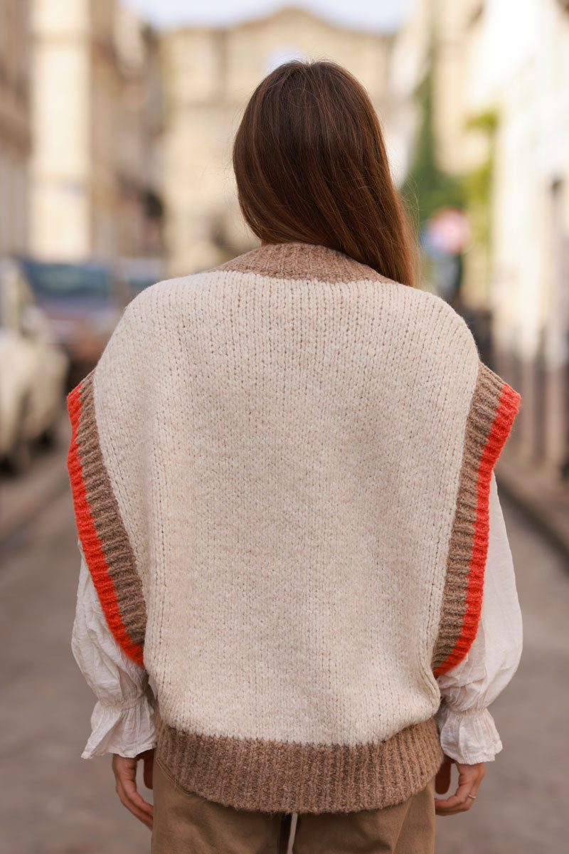 Jersey beige sin mangas de punto grueso con cuello de pico y ribetes de canalé color topo y naranja