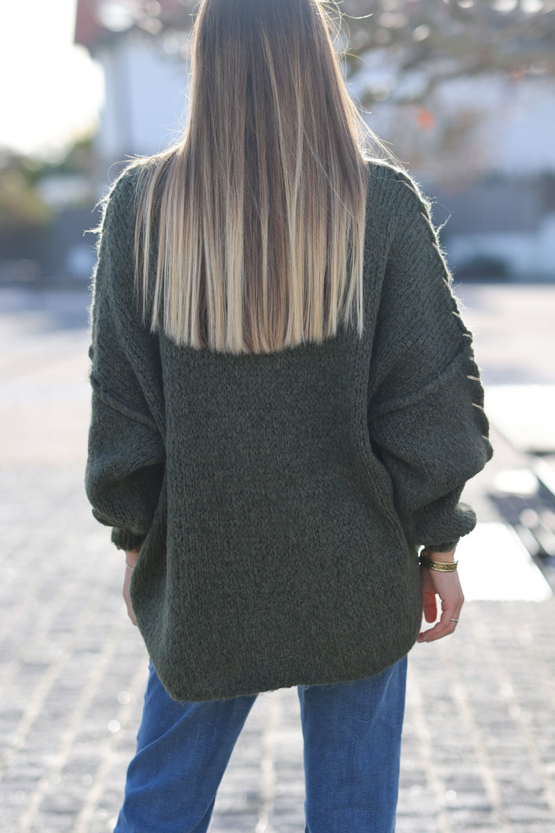 Jersey ancho de punto grueso caqui con cuello alzado y costuras vistas con pespuntes dorados