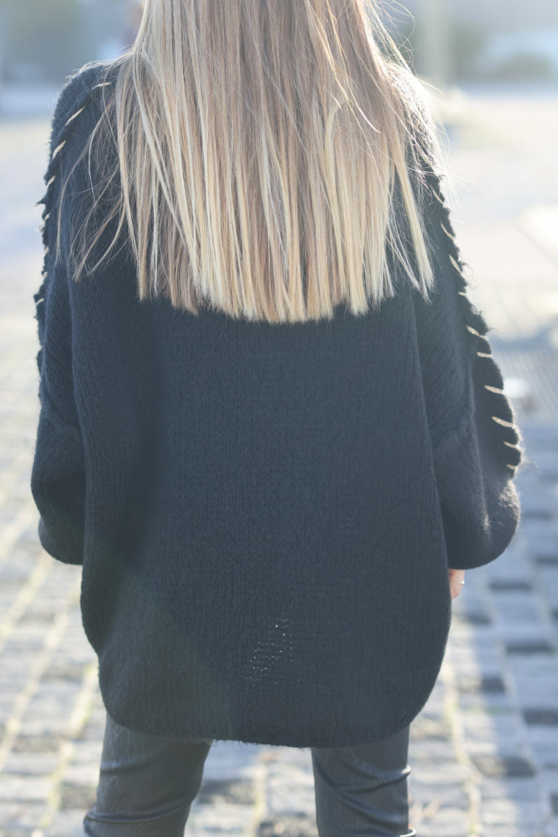 Jersey ancho de punto grueso negro con cuello alzado y costuras vistas con pespuntes dorados