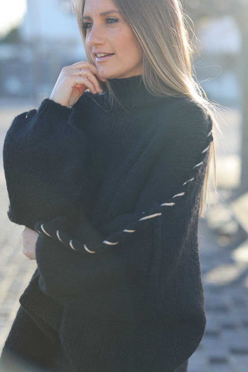 Jersey ancho de punto grueso negro con cuello alzado y costuras vistas con pespuntes dorados