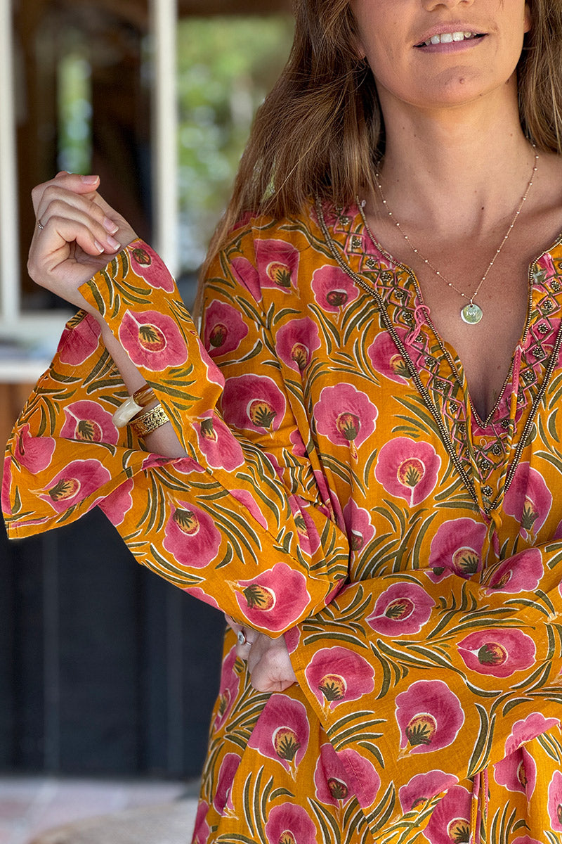 Robe longue orange en coton imprimé fleurs roses col perles et pompons