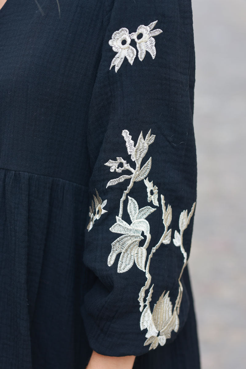 Vestido negro de gasa de algodón con escote en pico y bordado de flores beige en las mangas