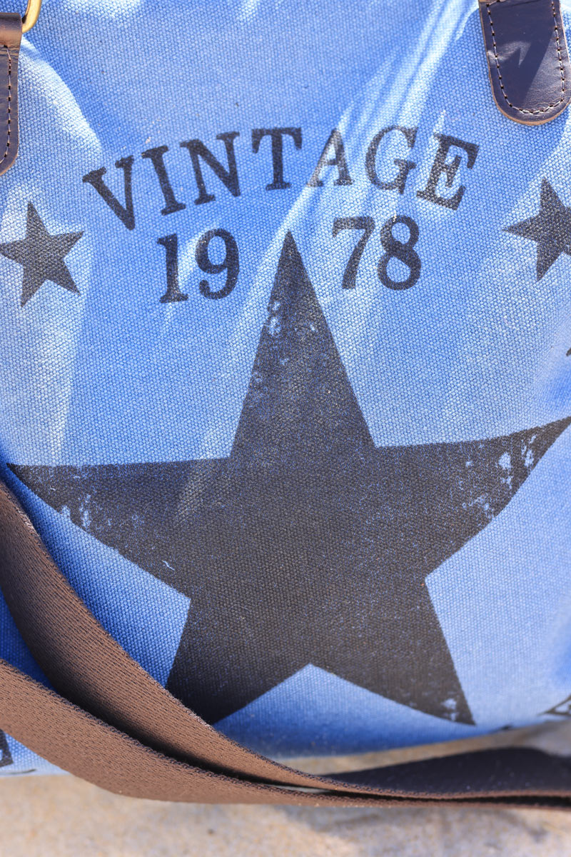 Bolso de mano de algodón denim azul y asas de piel con logo de estrella vintage