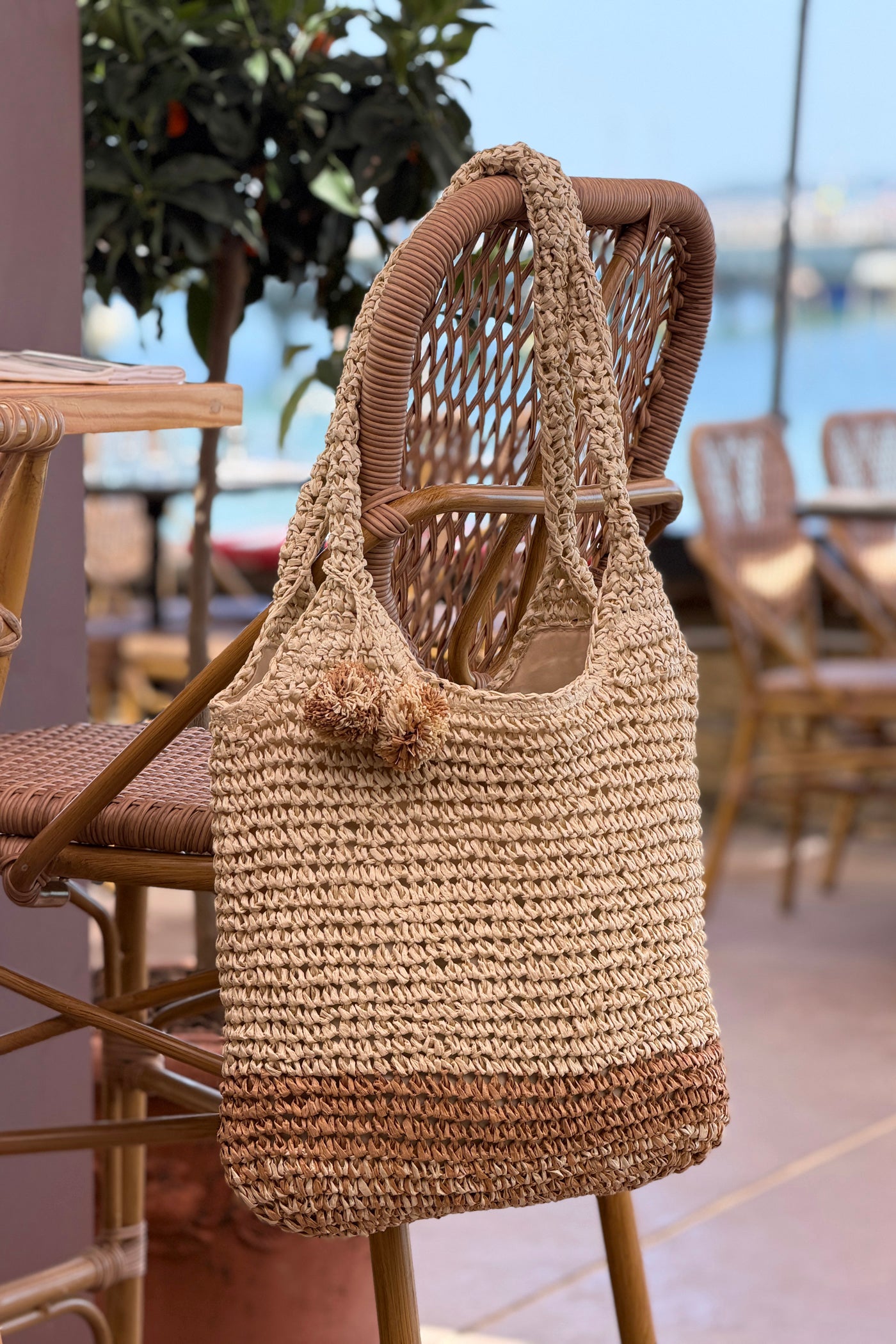 Sac effet paille tressée bicolore naturel et camel avec pompons