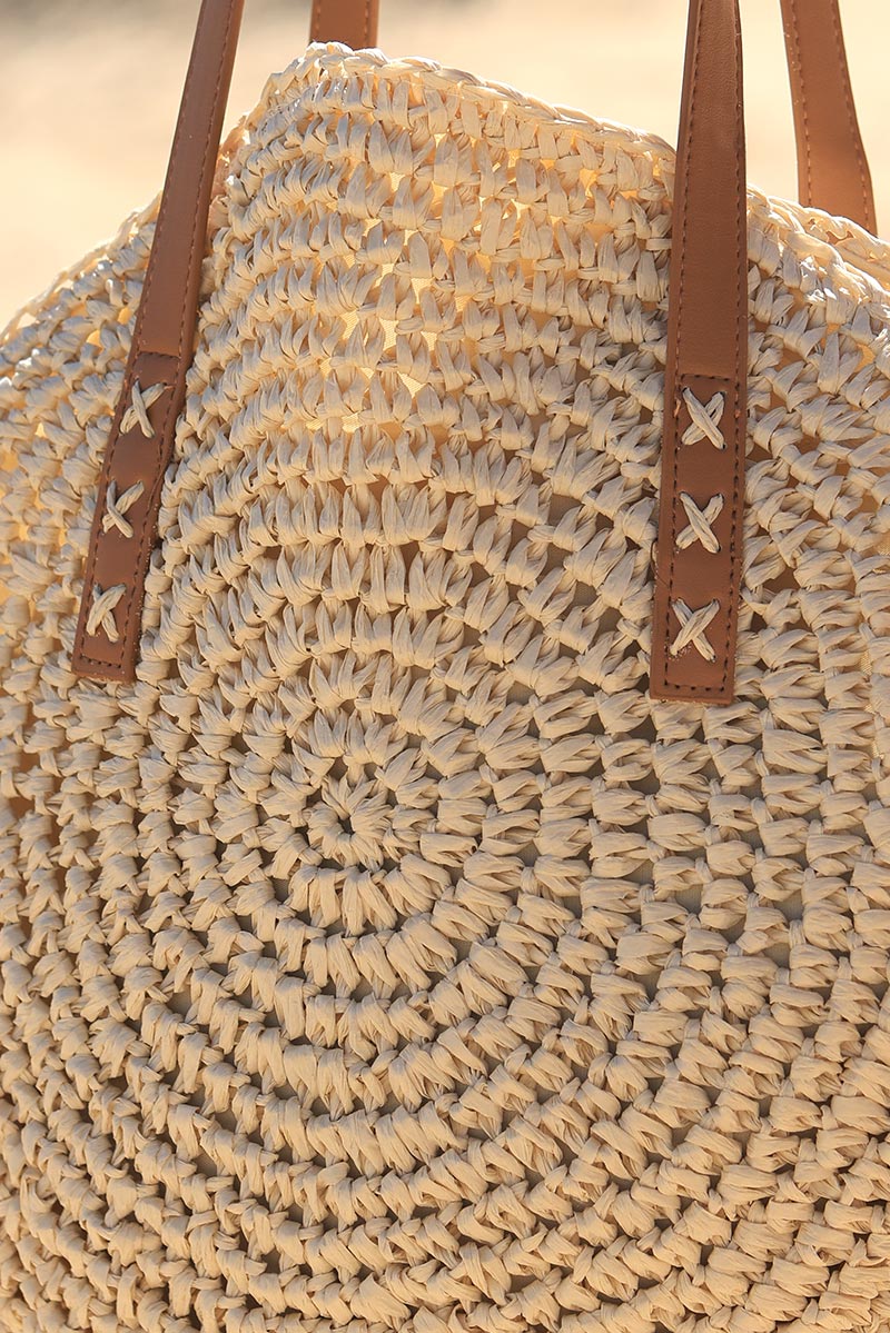 Ecru round raffia basket bag with faux leather handles