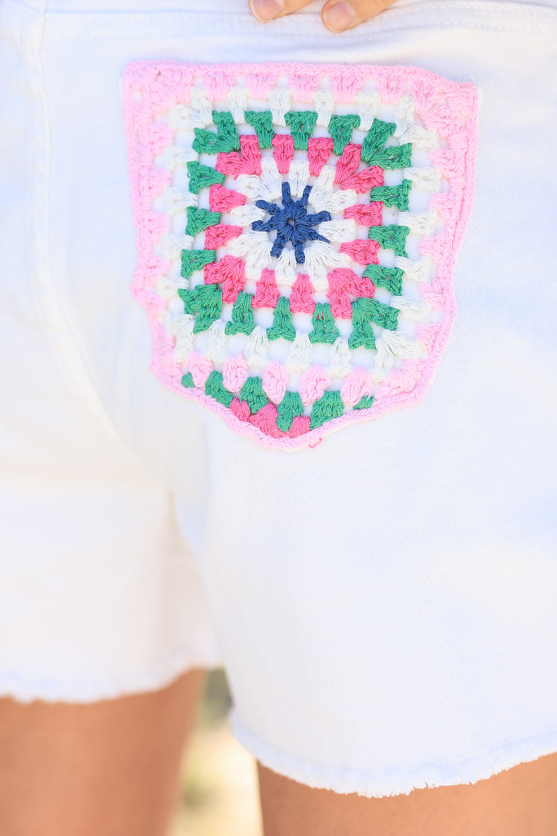 Short vaquero blanco roto con parches bordados en crochet de colores