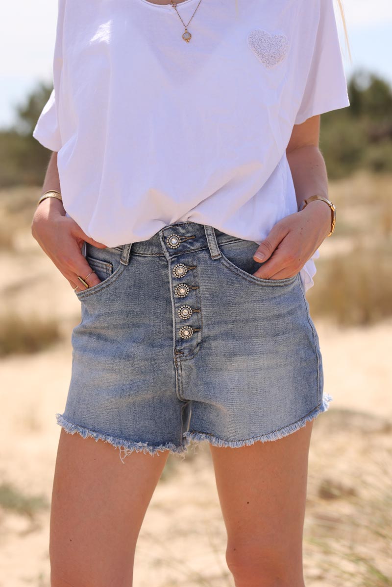 Light washed denim shorts with frayed hem and jewel buttons