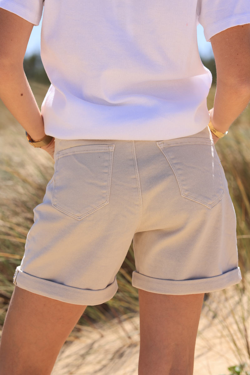 Short vaquero beige de talle alto con cinturón trenzado de conchas