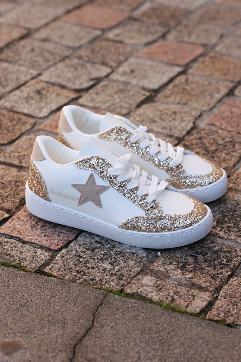 Tenis blancos con detalles de brillo dorado y estrella de ante beige