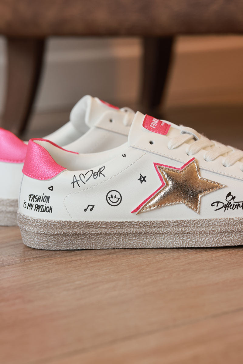 Tenis blancos con estrella dorada, detalles fucsia y graffitis