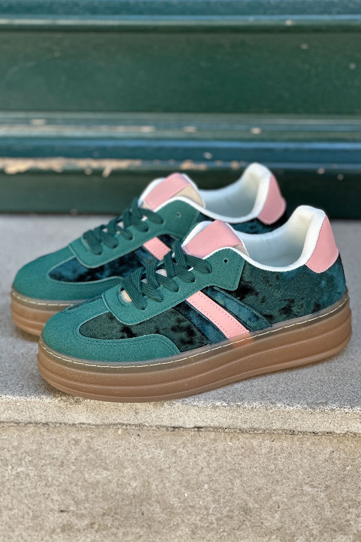 Zapatillas de tenis de plataforma de terciopelo verde con rayas y tacón rosa.