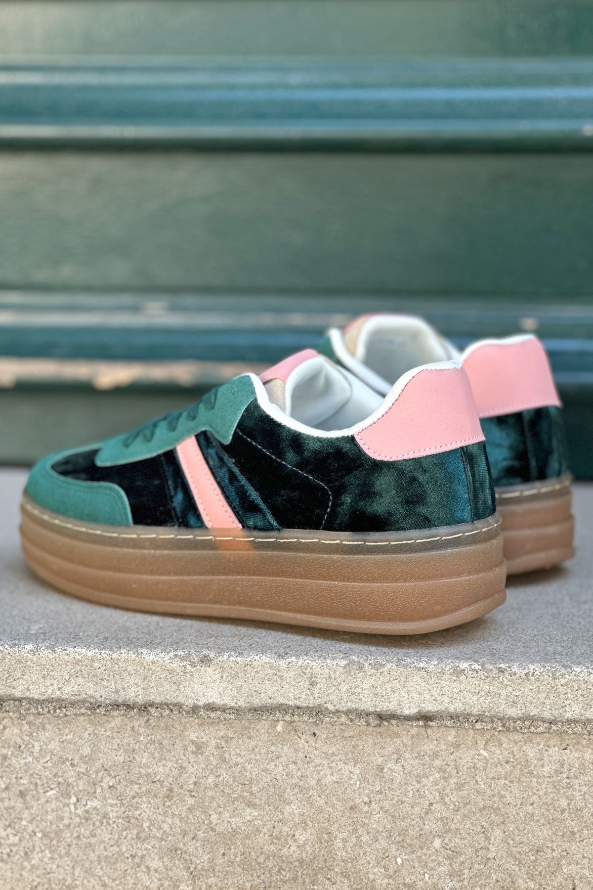 Zapatillas de tenis de plataforma de terciopelo verde con rayas y tacón rosa.