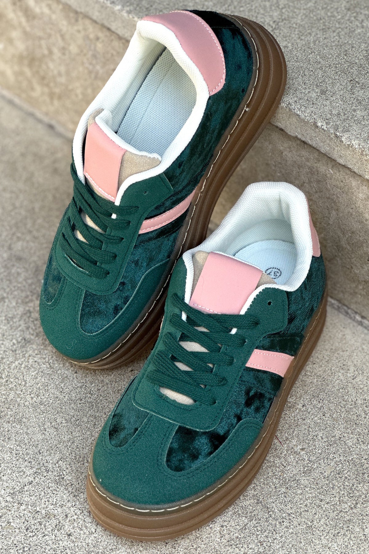 Zapatillas de tenis de plataforma de terciopelo verde con rayas y tacón rosa.
