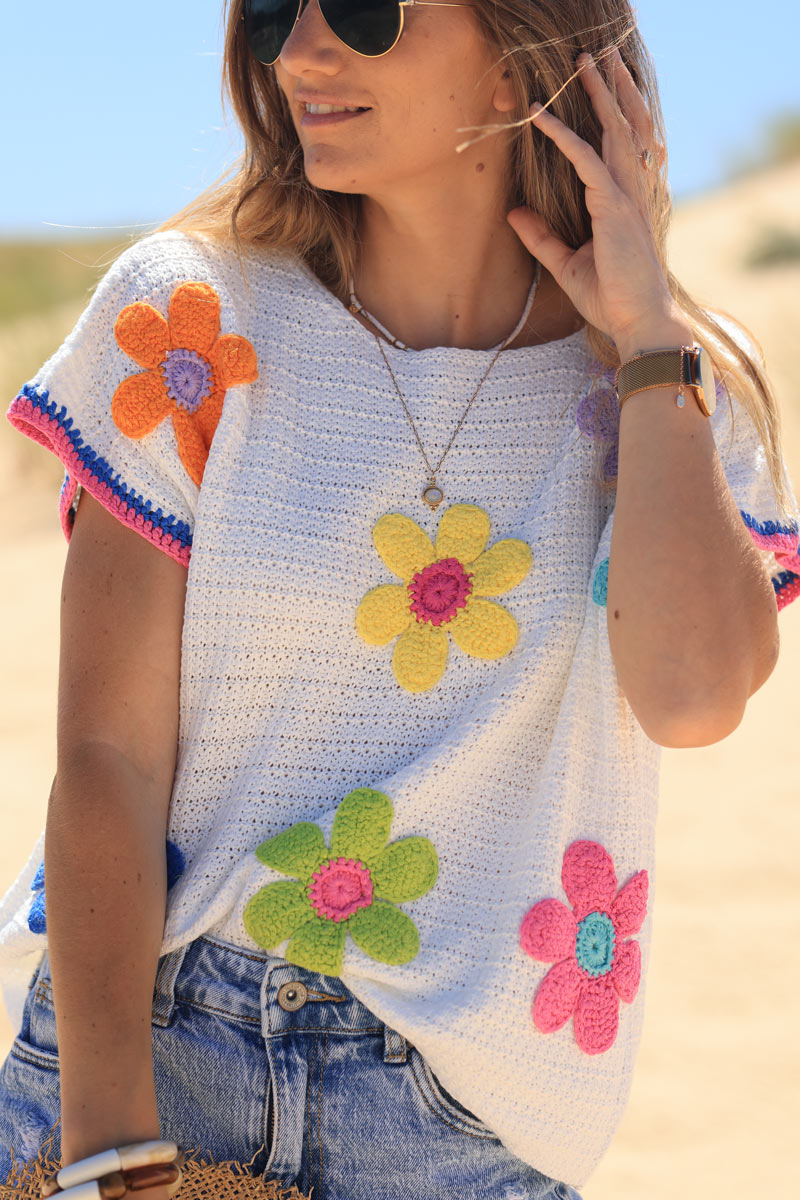 Top de crochet blanco con manga corta y flores de colores.