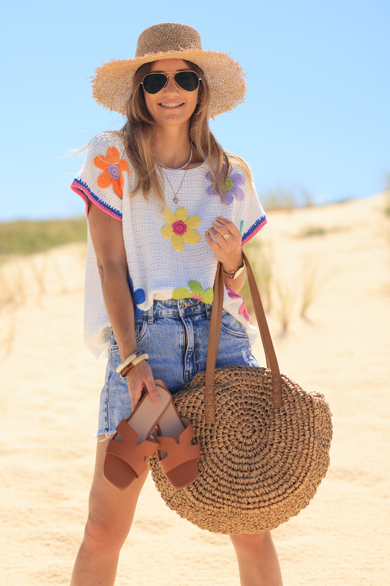 Top de crochet blanco con manga corta y flores de colores.