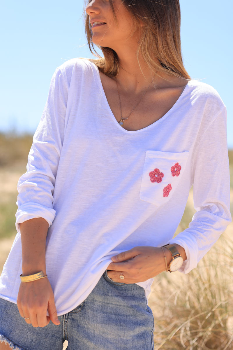 Camiseta blanca de manga larga con bolsillo fucsia y flores bordadas brillantes