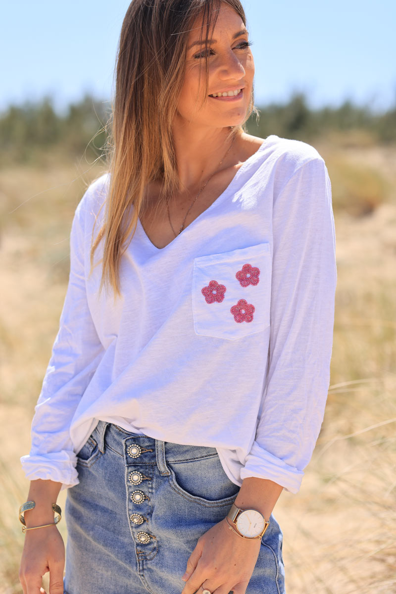 White long sleeve top with fuchsia embroidered pocket flowers