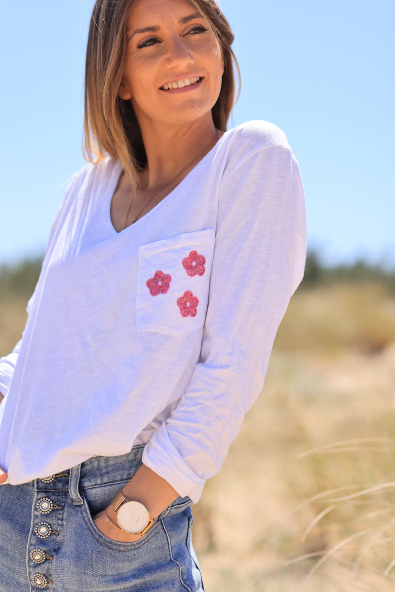 White long sleeve top with fuchsia embroidered pocket flowers