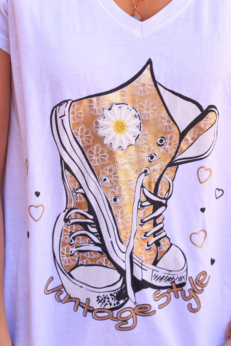 Camiseta de algodón blanca con zapatillas doradas y bordado de flores.