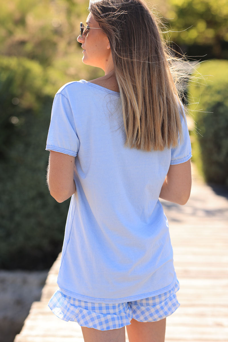 Camiseta de algodón azul cielo desteñida con cuello de pico y estrella dorada brillante en el bajo