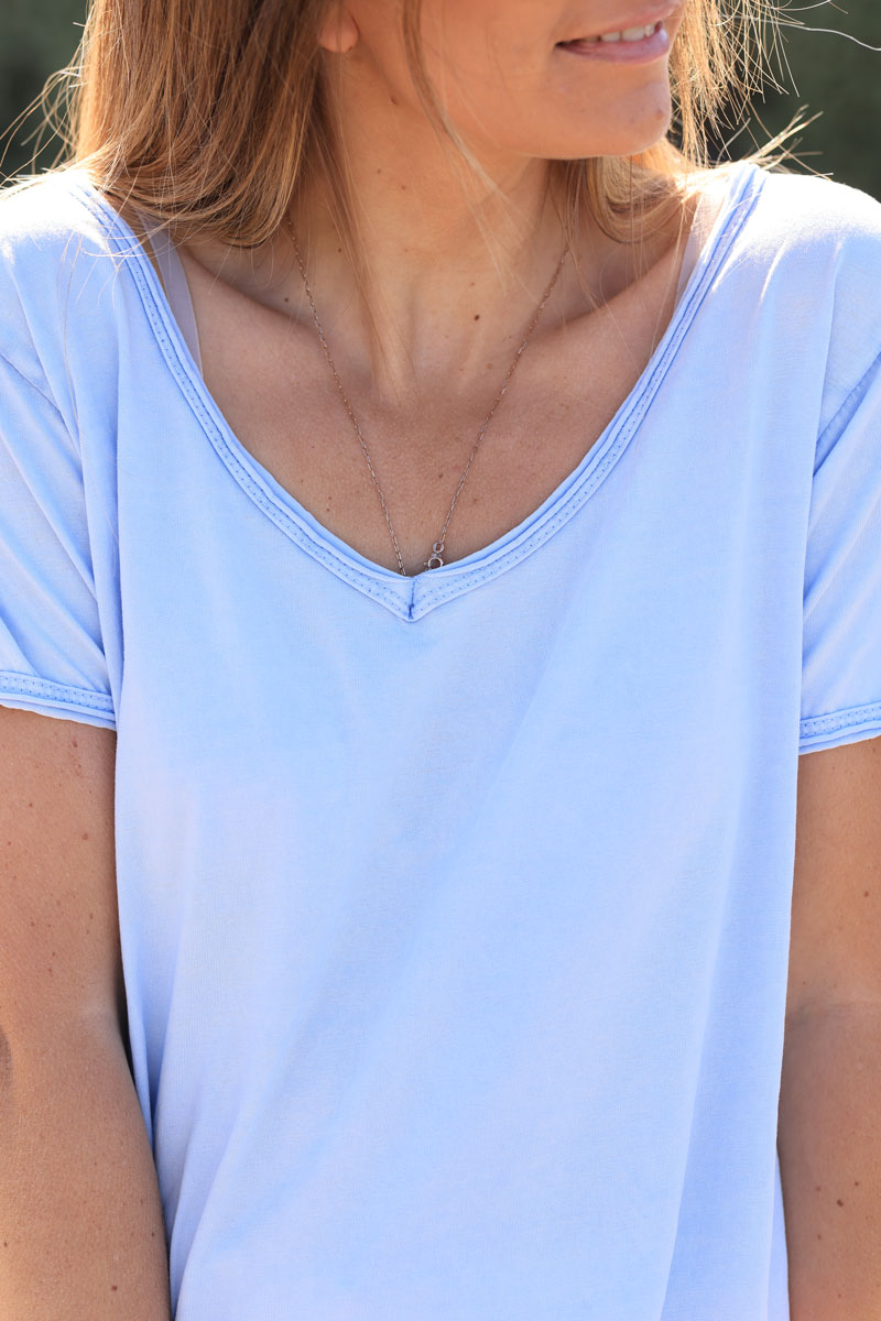 Camiseta de algodón azul cielo desteñida con cuello de pico y estrella dorada brillante en el bajo