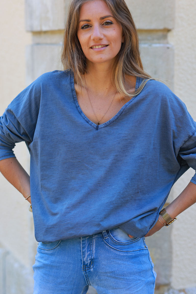 Camiseta azul lavada de manga larga con cuello de pico y parche mensaje en la espalda