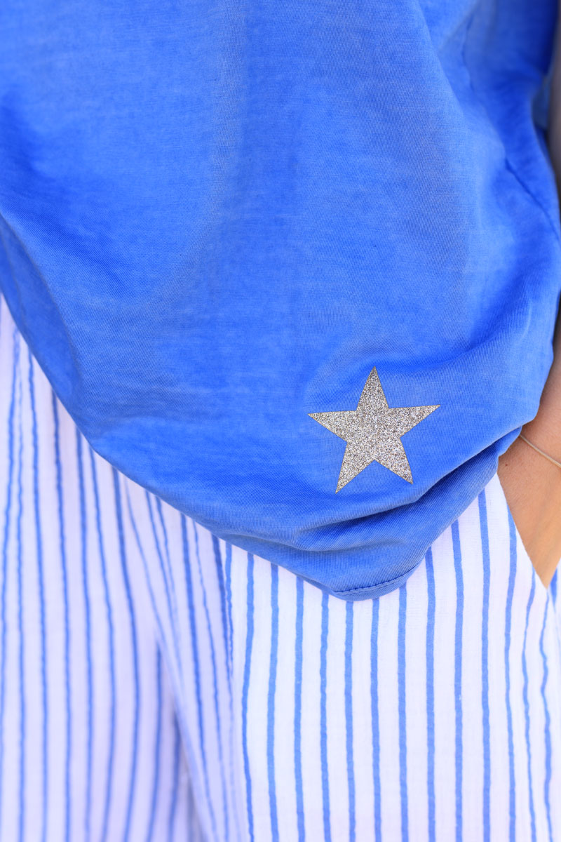 Camiseta de algodón azul real desteñido con cuello de pico y estrella dorada brillante en el bajo