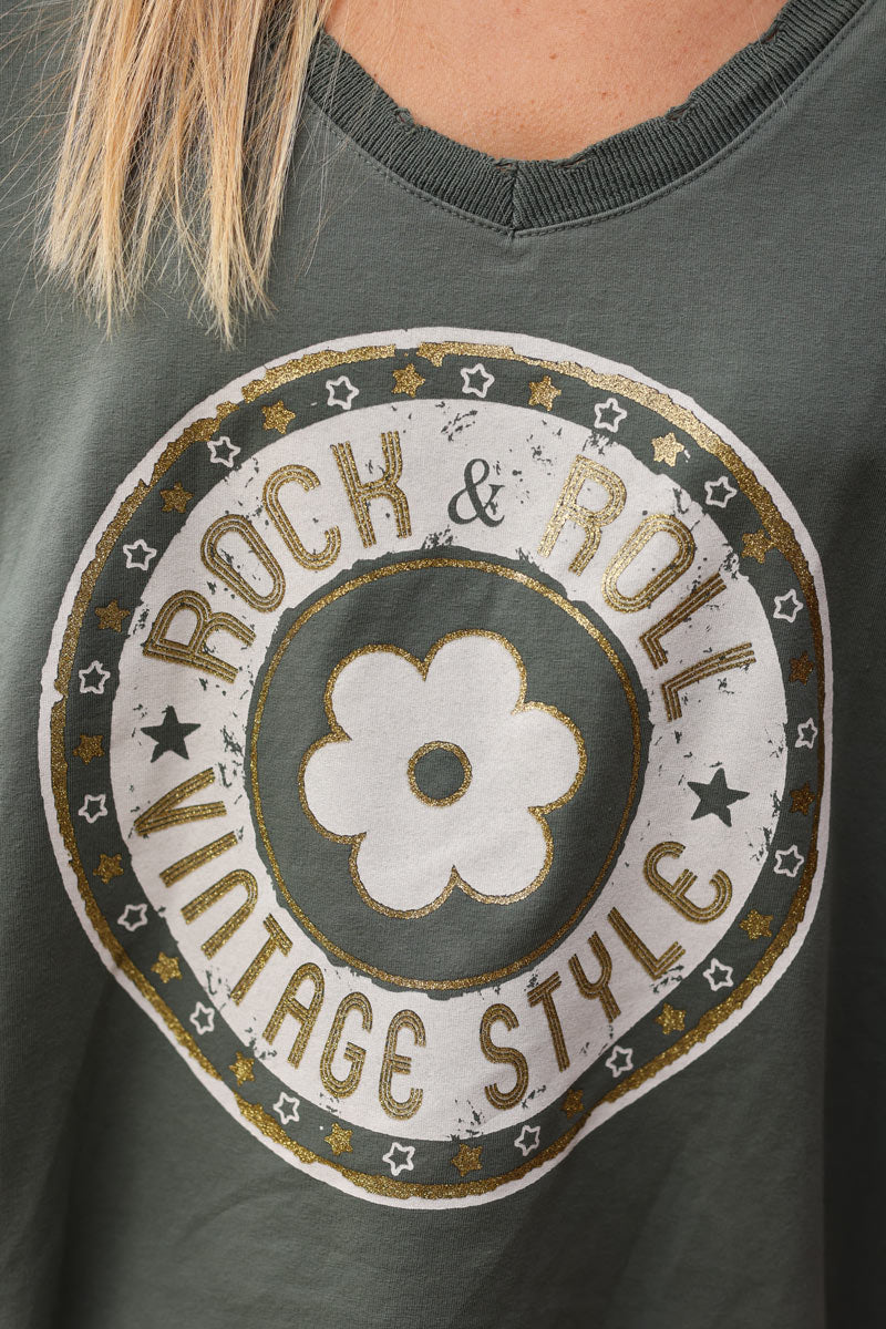 Camiseta caqui gruesa de manga larga con cuello en pico, flores y logo de rock roll brillante