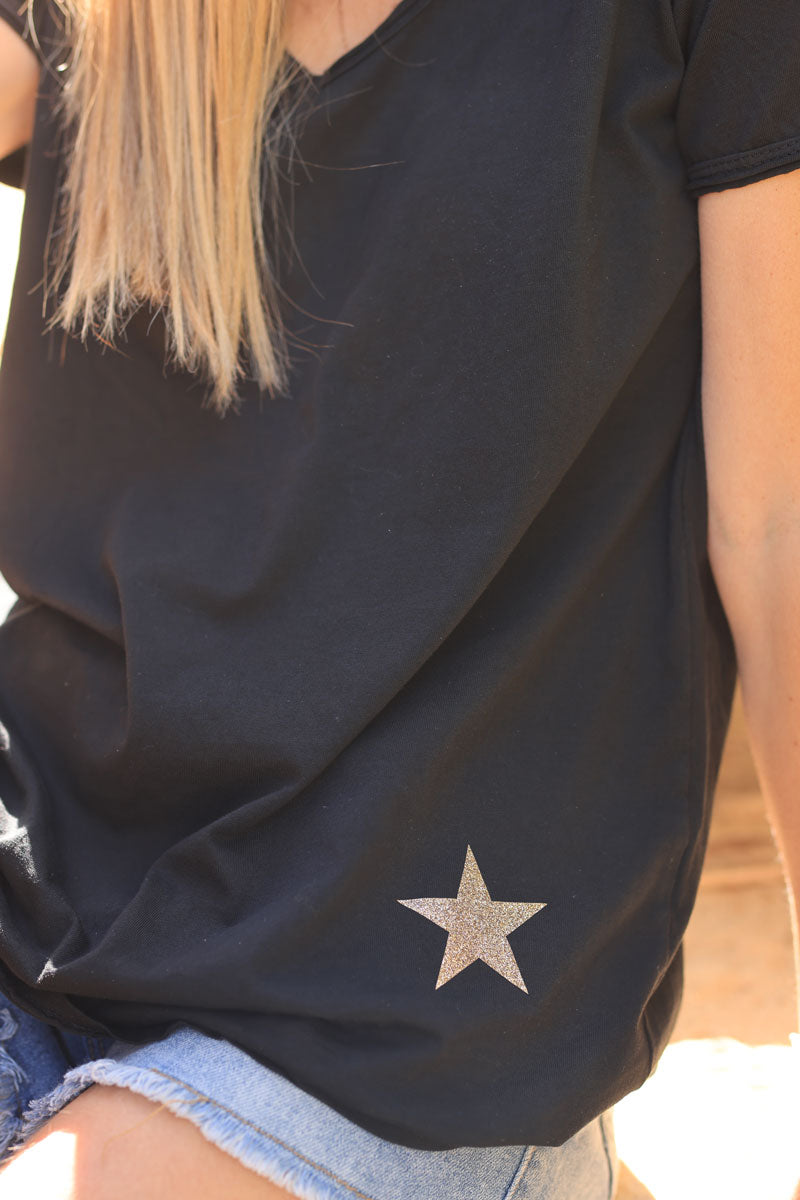 Camiseta negra de algodón con cuello de pico y estrella dorada brillante en el bajo