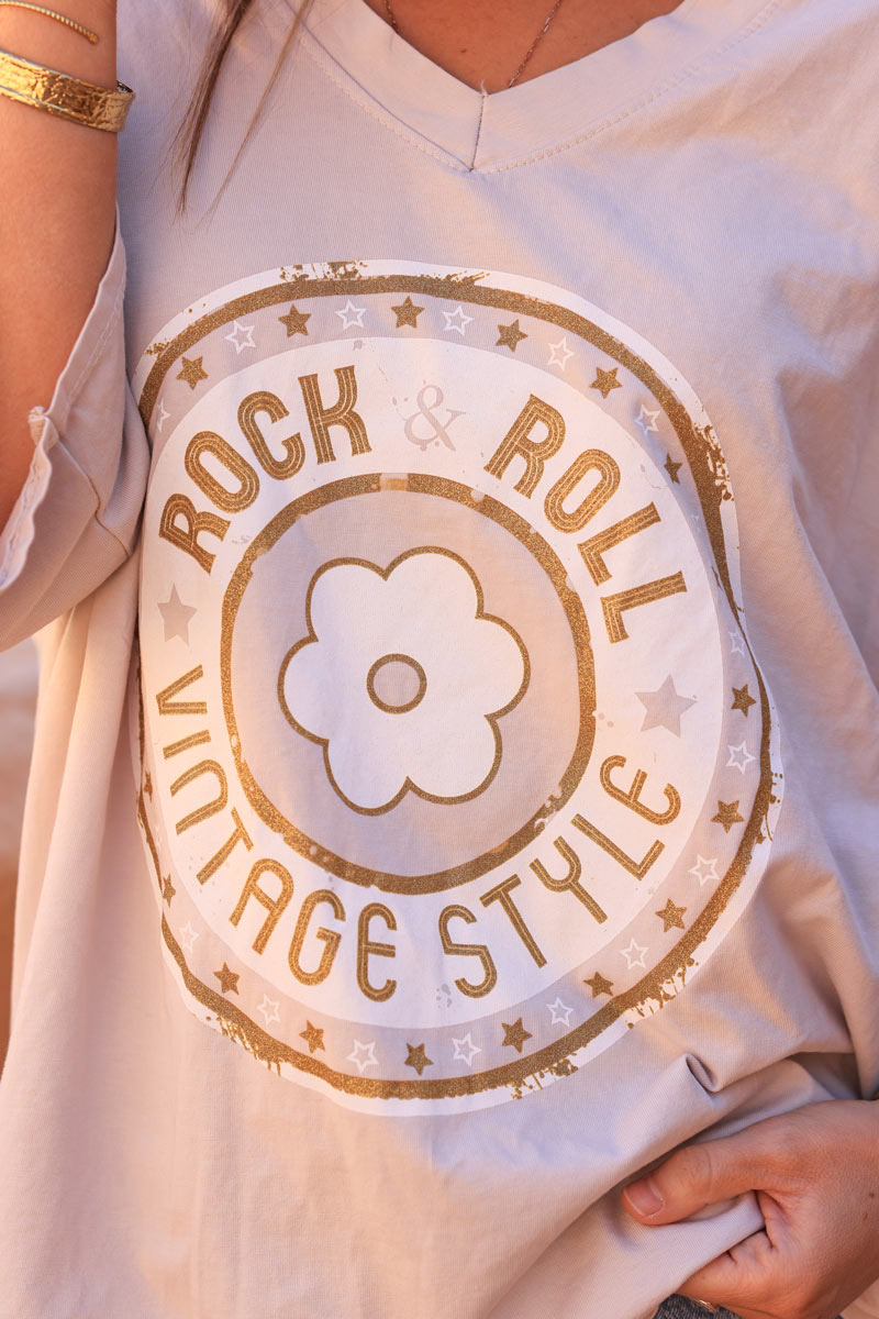 Camiseta beige elástica y holgada con cuello en pico, manga ancha, logo rock de flores y lentejuelas