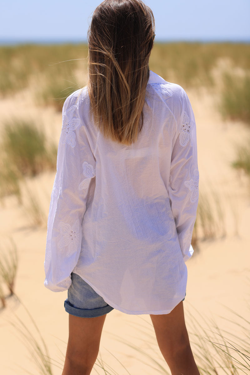 Túnica blanca con camisa de cuello pico y bordado de flores.