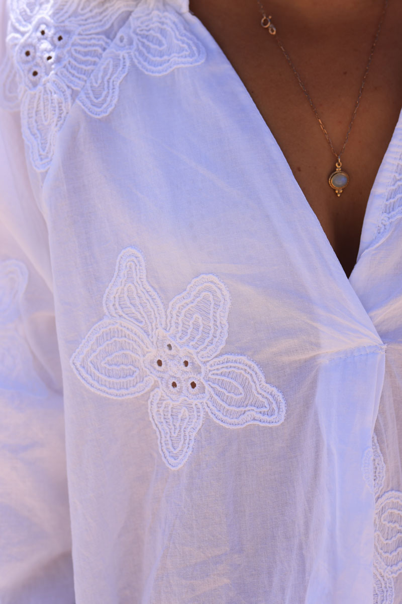 Túnica blanca con camisa de cuello pico y bordado de flores.