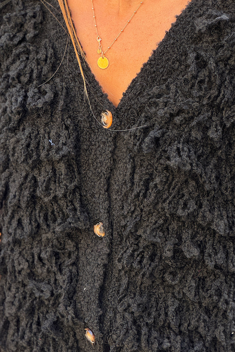 Veste sans manches en grosse maille bouclette noire effet franges boutons écaille