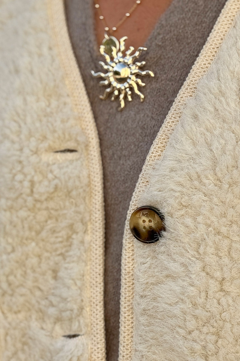 Veste sans manches en moumoute beige détail liseré beige boutons écaille marron